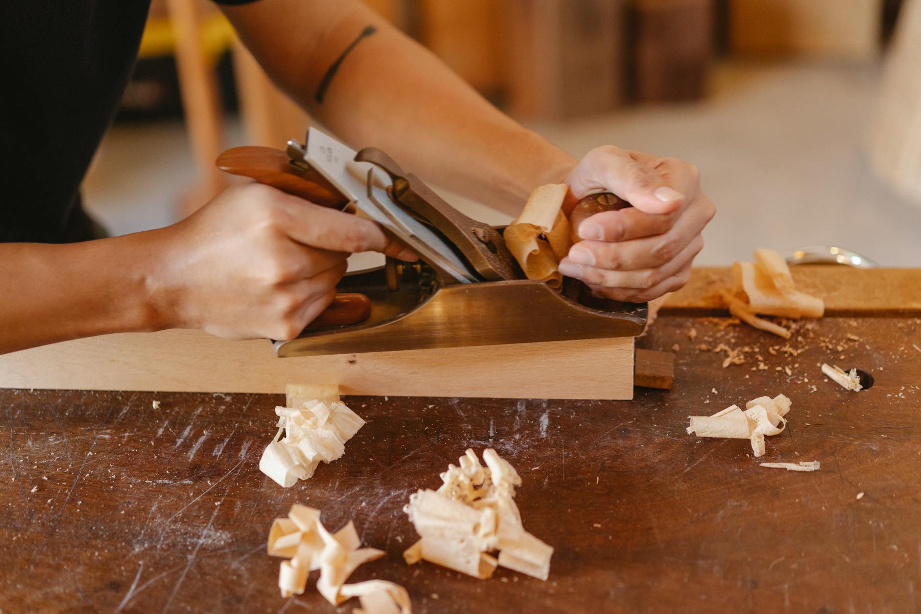 Tischler bearbeitet Holz in der Werkstatt